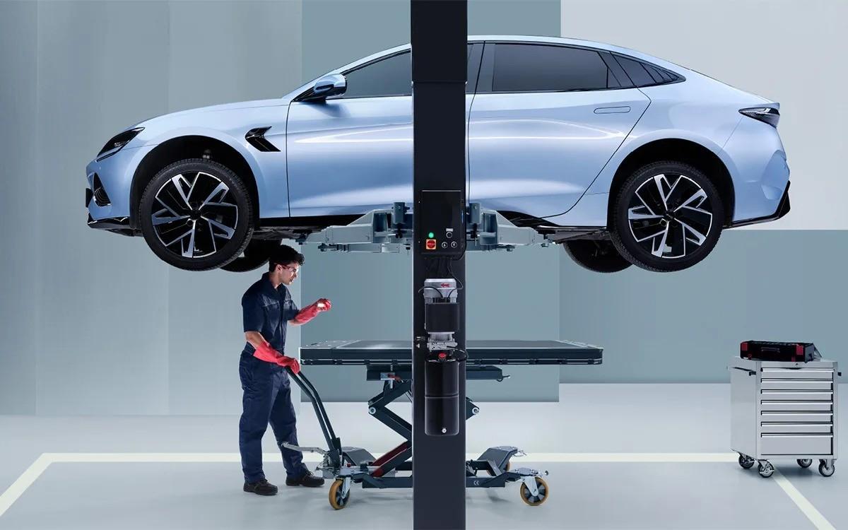 Kỹ thuật viên thao tác với bộ pin được hạ khỏi gầm xe, công đoạn đòi hỏi thiết bị chuyên dụng và chứng chỉ điện áp cao.