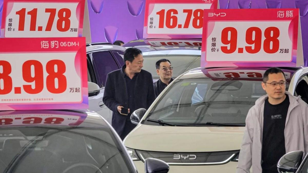 Bảng giá khuyến mại dựng kín một đại lý tại Trung Quốc. Mỗi lần giá xe mới được hạ, khoản chênh lệch được trừ thẳng vào tài sản của những người đã mua trước đó.