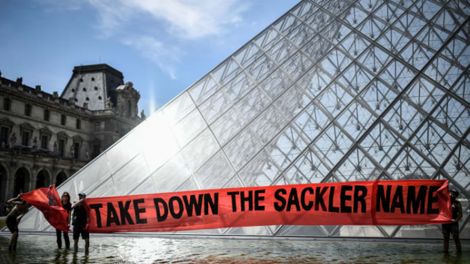 Băng rôn phản đối được giăng trước Pyramid of the Louvre tại Paris (Ảnh: Stephane De Sakutin/AFP/Getty Images)