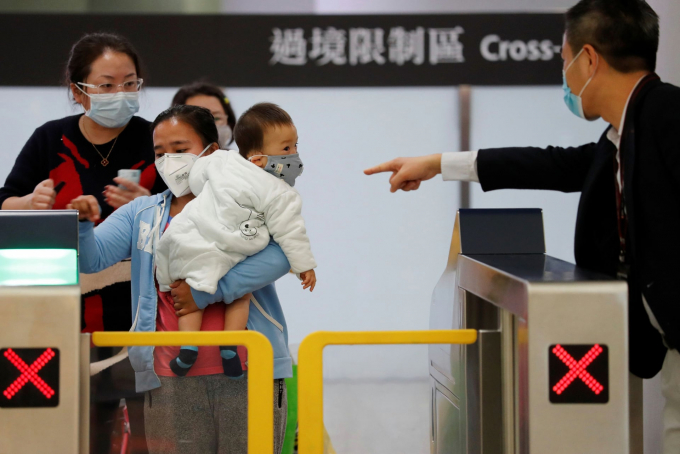 Hành khách đeo khẩu trang bảo vệ virus corona tại ga tàu (Ảnh: Tyrone Siu/Reuters).