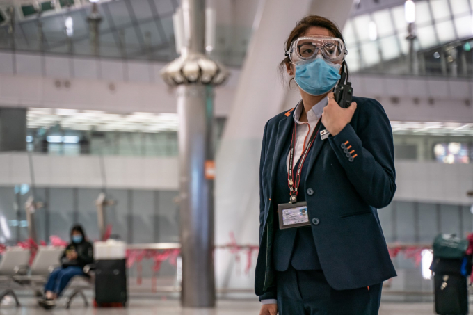 Nhân viên MTR đeo kính bảo vệ và khẩu trang đứng ở sảnh đến trạm tàu cao tốc ở Hong Kong (Ảnh: Anthony Kwan/Getty Images).