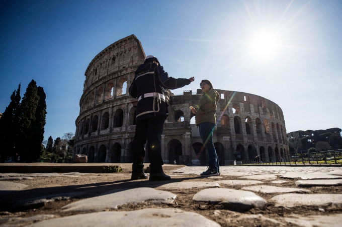 Một sĩ quan cảnh sát đang nói chuyện với một khách du lịch bên ngoài đấu trường ở Rome (Ảnh: Angelo Carconi/EPA).