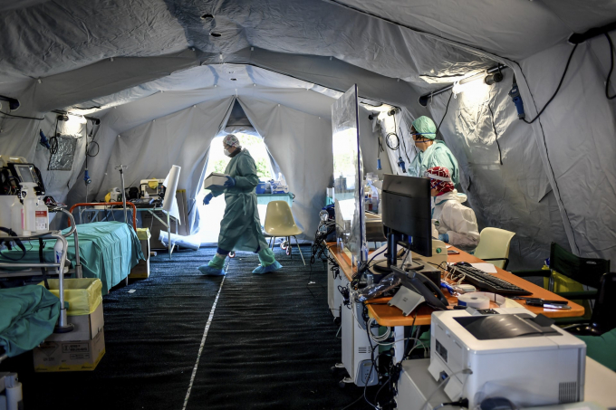 Nhân lực y tế làm việc bên trong một khu lều dựng tạm bên ngoài bệnh viện Brescia để giảm tải các quy trình khám bệnh (Ảnh: Claudio Furlan/AP).