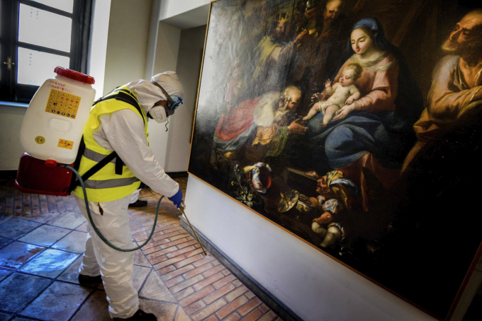 Một nhân viên phun dung dịch khử khuẩn tại một bảo tàng ở Maschio Angioino (Ảnh: Alessandro Pone/AP).