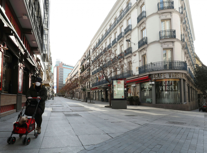 Hình ảnh một phụ nữ đeo khẩu trang dạo bước trên con phố trung tâm từng rất đông đúc tại Madrid. Hiện Tây Ban Nha đã tuyên bố tình trạng khẩn cấp 15 ngày để chống dịch bệnh (Ảnh: Sergio Pérez/Reuters).