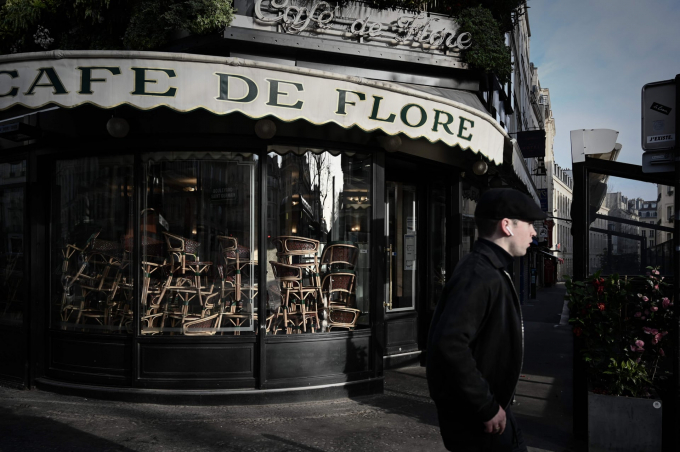 Một chàng trai đi qua quán Café de Flore hiện đã đóng cửa tại quận Saint-Germain-des-Pres (Ảnh: Philippe Lopez/AFP via Getty Images).
