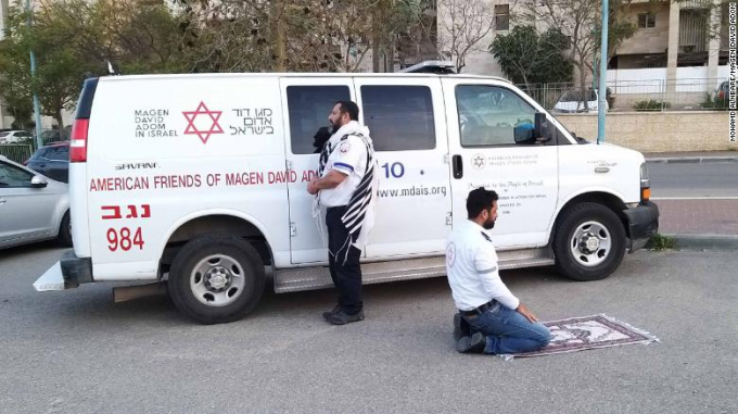 Trong khi nhân viên y tế theo đạo Do Thái Avraham Mintz quay mặt về Jerusalem cầu nguyện thì Abu Jama theo đạo Hồi cũng quỳ xuống cầu nguyện trước tấm thảm của mình (Ảnh: CNN).  