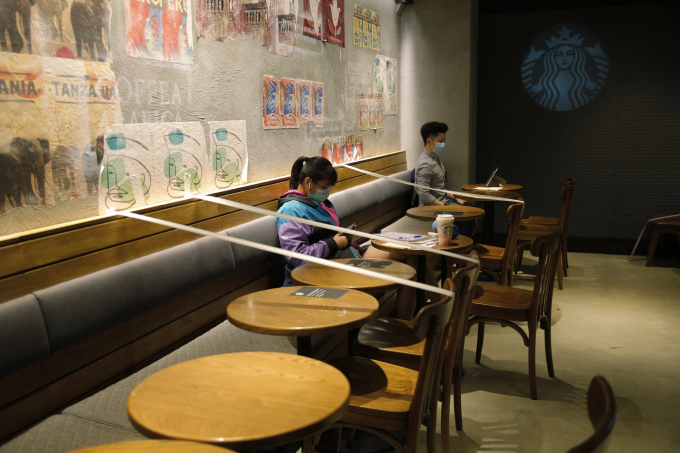   Hong Kong, Trung Quốc: Bàn và ghế tại một quán Starbucks được dán băng dính để buộc khách hàng phải thực hiện khoảng cách an toàn (Ảnh: Kin Cheung/AP).  