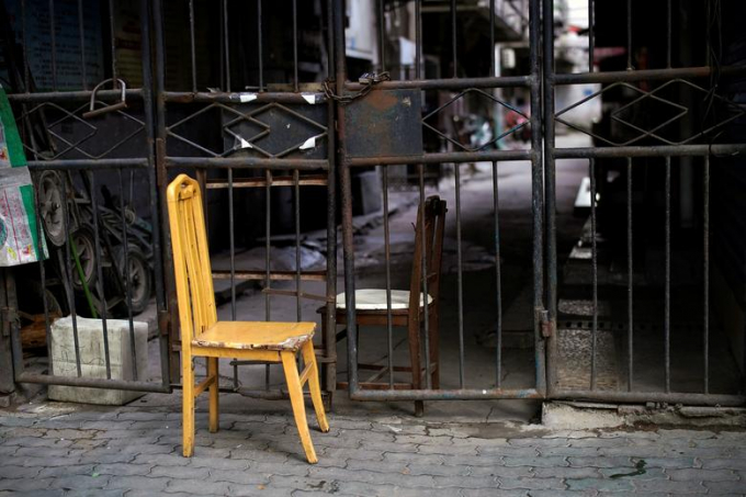 Hai chiếc ghế được dựng tại một lối vào nhà dân bị đóng cửa (Ảnh: Reuters/Aly Song).