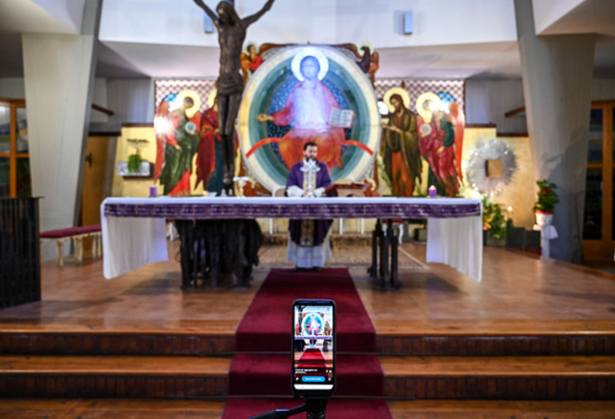 Linh mục Don Piero Belluso live stream trực tiếp cử hành lễ trong một nhà thờ vắng để không ảnh hưởng đến các giáo dân (Ảnh: Fabrizio Villa | Getty Images).
