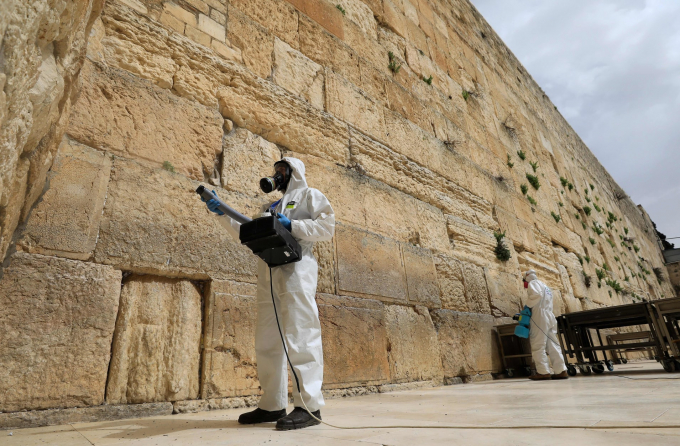 Nhân viên khử khuẩn bức tường phía Tây, một địa danh linh thiêng đối với người Do Thái hôm 31/3 nhằm ngăn sự lây lan đại dịch Covid-19 (Ảnh: Emmanuel Dunand | AFP | Getty Images).