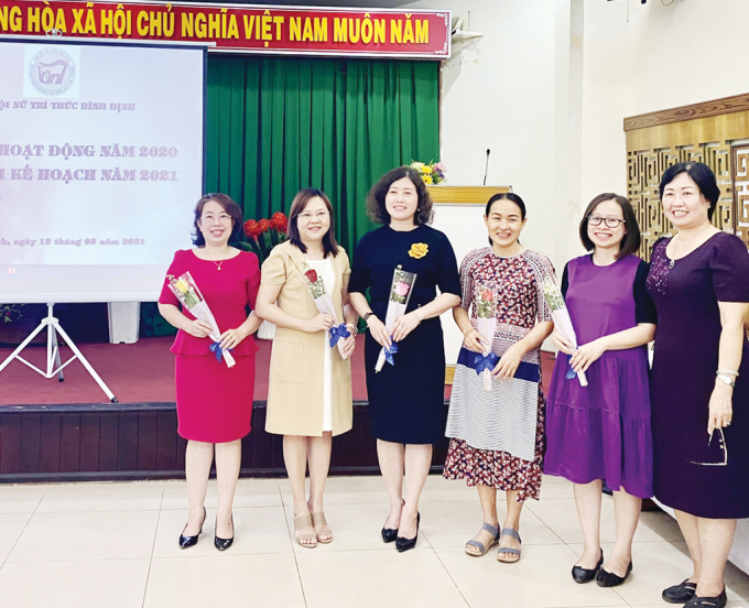 Bà Nguyễn Thị Thanh Bình - Chi hội trưởng Chi hội Nữ trí thức Bình Định (bìa phải) tặng hoa chúc mừng các hội viên mới kết nạp trong năm 2020 tại hội nghị tổng kết hoạt động năm 2020.