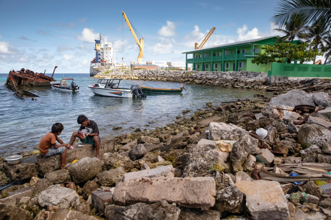 Những cậu bé làm sạch cá dọc theo bờ biển của Đảo Ebeye trong đảo san hô Kwajalein của Quần đảo Marshall vào tháng 7/2019 (Ảnh: CNN).