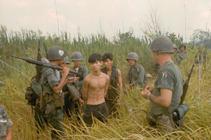 Những người lính Việt Nam và một người lính Hoa Kỳ cùng với hai tù binh bị bắt bị tình nghi là du kích Việt Cộng (Ảnh: Tim Page/Corbis via Getty Images).