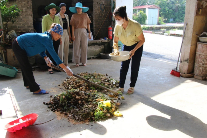 Chị Tuyến (bìa phải) cùng bà con đang chuẩn bị nguyên liệu để làm phân bón vi sinh.