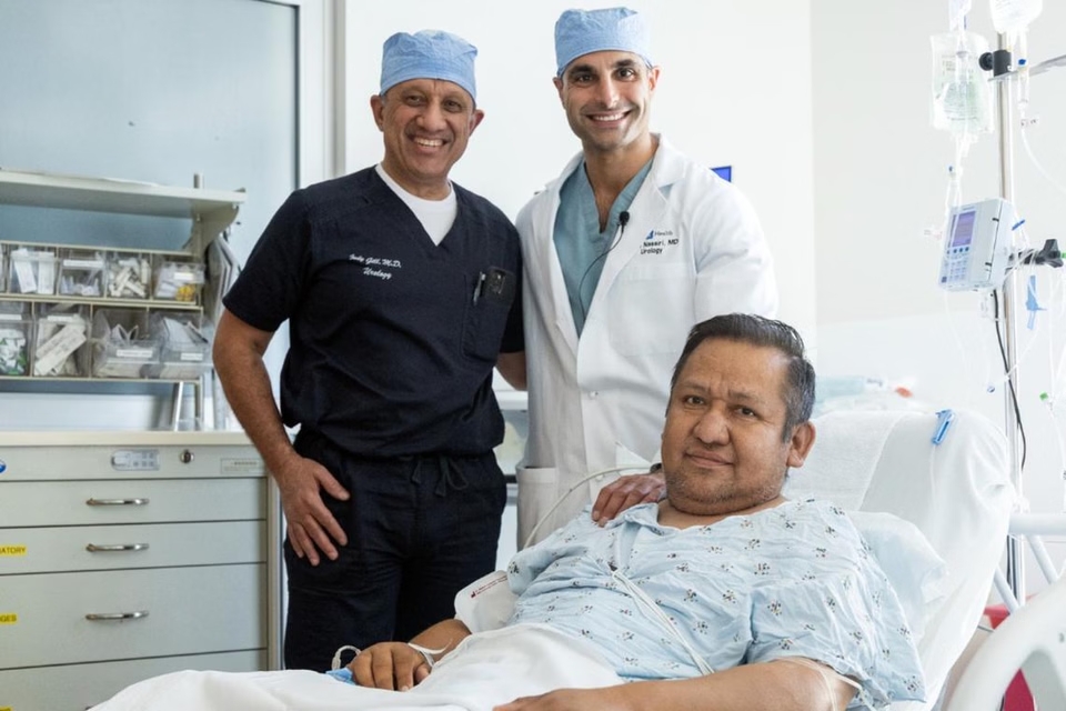 Bác sĩ Inderbir Gill (trái) là người thực hiện ca phẫu thuật cùng với bác sĩ Nima Nassiri, chụp cạnh ông Oscar Larrainzar, bệnh nhân đầu tiên được thực hiện ca ghép lịch sử.