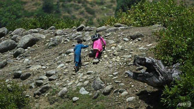 Để tới được trường học, các em phải leo qua những trườn dốc khá cao và trơn trượt (Ảnh: AFP)