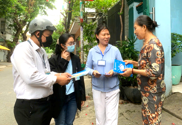 Nhân viên y tế và CTV phát tờ rơi tuyên truyền cho người dân xung quanh khu vực điểm nguy cơ. Ảnh: Sở Y tế TP.HCM