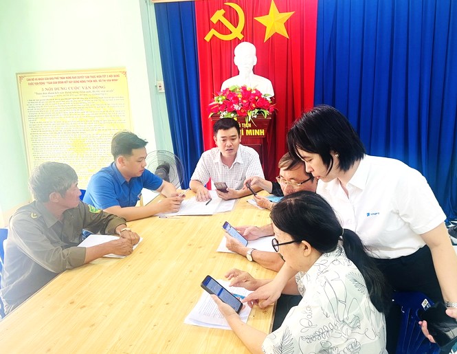 Thành viên Tổ công nghệ số cộng đồng khu phố Trần Hưng Đạo, phường Tuy Hòa hướng dẫn người dân sử dụng App Đắk Lắk số. Ảnh: Sở KH-CN