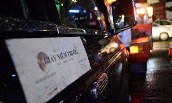 Ông Đoàn Ngọc Hải 'đội mưa' cẩu xe biển xanh 80B đậu trên vỉa hè