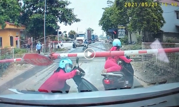 Người phụ nữ liều lĩnh băng qua đường sắt dù barie đã đóng