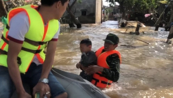 Người đàn ông nhảy xuống dòng nước lũ bế em bé lên nhận hàng cứu trợ