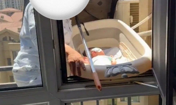 Mẹ mang con ra ngoài cửa sổ tầng cao để 'phơi nắng trị vàng da', cư dân mạng hoảng hốt