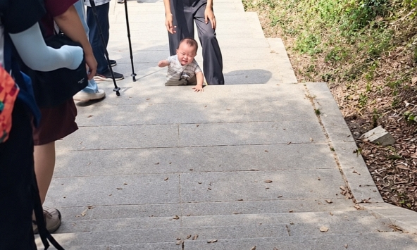 Bố mẹ để con nhỏ 9 tháng tuổi bò bằng tay chân trần lên núi khiến dân mạng bùng nổ tranh cãi